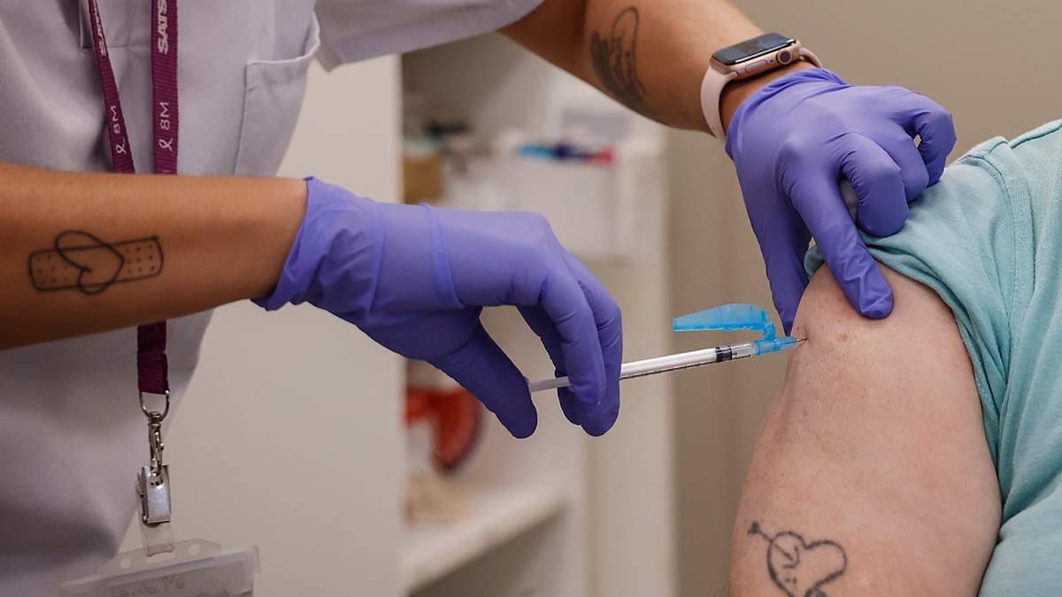 Una mujer se vacuna durante el inicio de la campaña de vacunación frente a la gripe y la Covid-19