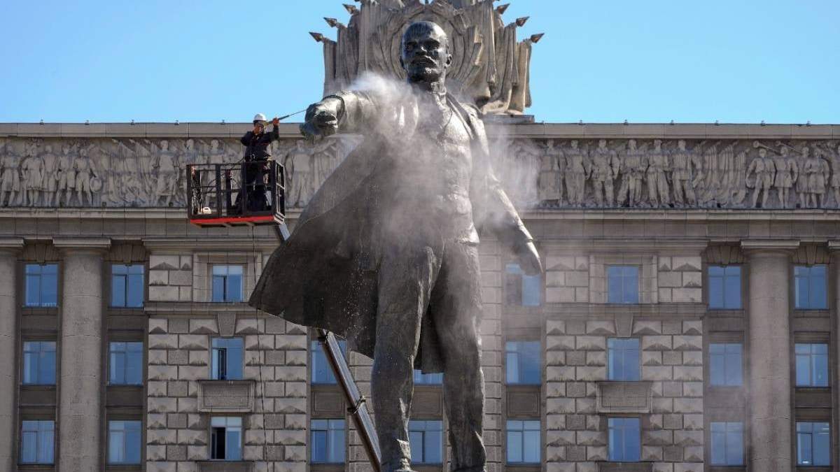 Bomberos extinguen un incendio luego de que un ataque ruso destruyera un edificio en Kharkiv, Ucrania, el 12 de abril. En la imagen se ve una estatua de Lenin