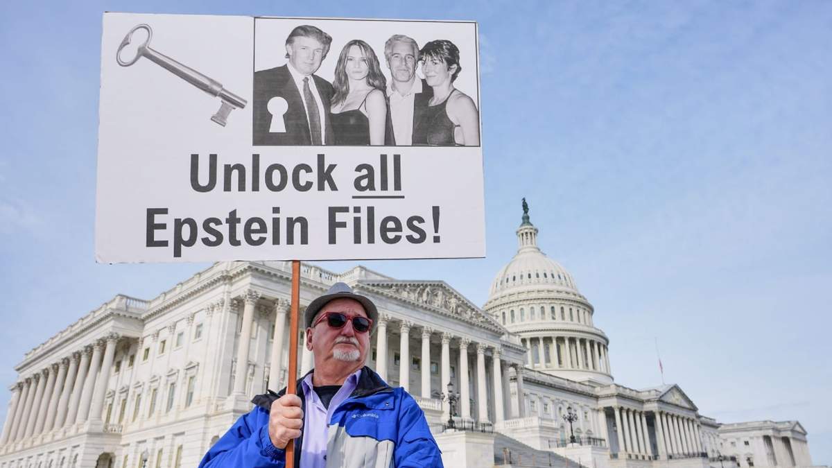 Gary Rush, de College Park, Maryland, sostiene un cartel antes de una conferencia de prensa sobre los expedientes de Epstein frente al Capitolio de Washington