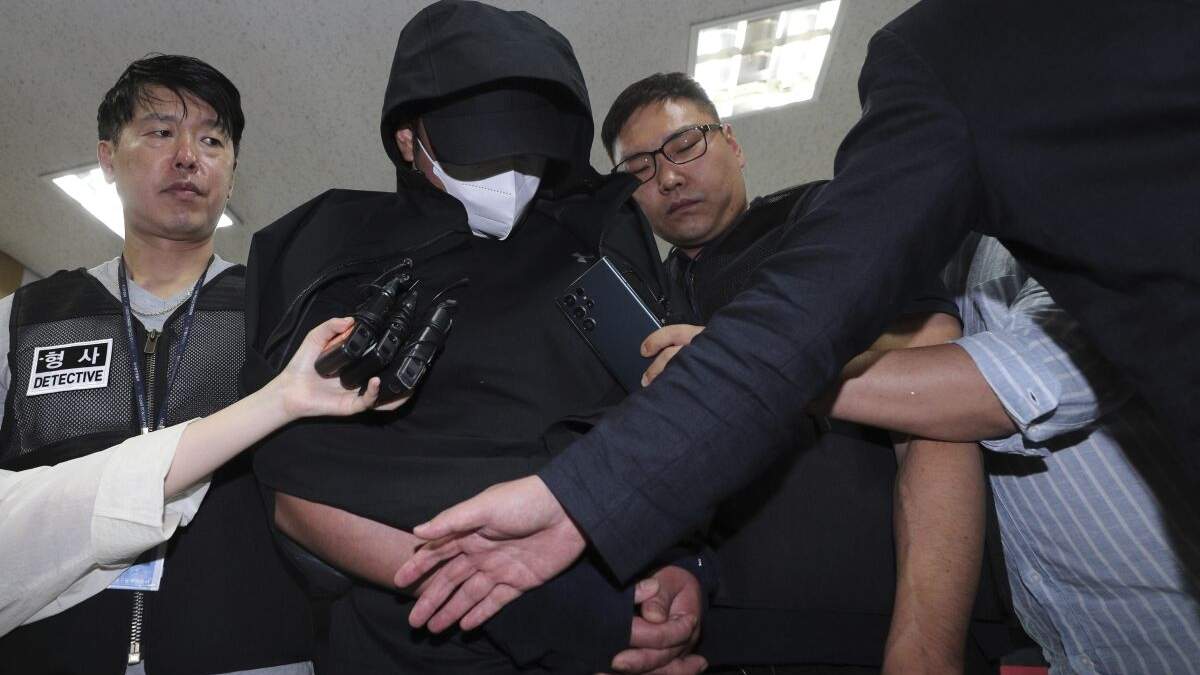 La policía lleva arrestado al hombre que abrió una puerta de emergencia durante un vuelo en Corea del Sur, en Daegu el domingo 28 de mayo de 2023