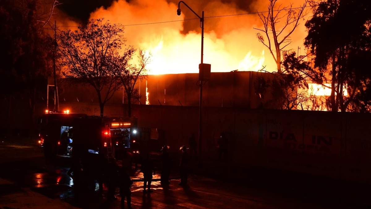 Bomberos trabajan para extinguir el fuego en la Central de Abasto