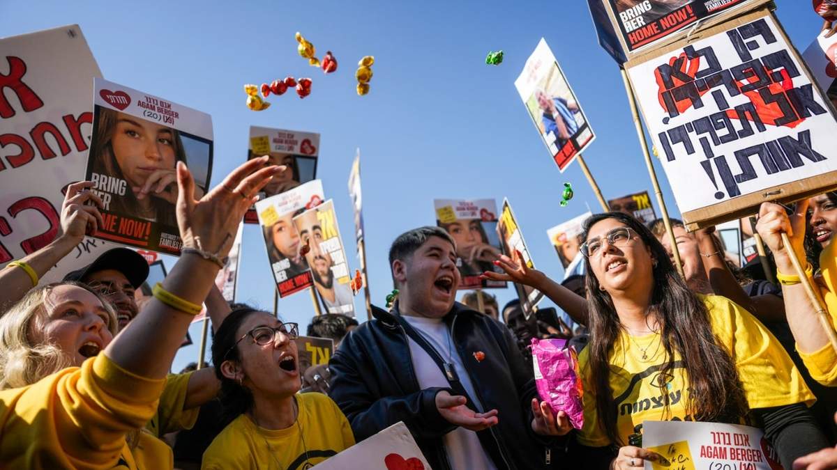 Gente reacciona mientras ve la retransmisión de la liberación de la soldado israelí Agam Berger, una de los ocho rehenes que estaba previsto liberar el jueves como parte del cese el fuego en la Franja de Gaza, en Tel Aviv, Israel