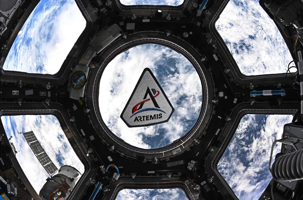 En esta fotografía proporcionada por la NASA, se observa un parche del programa Artemis flotando en la cúpula de la Estación Espacial Internacional, el 30 de marzo de 2026