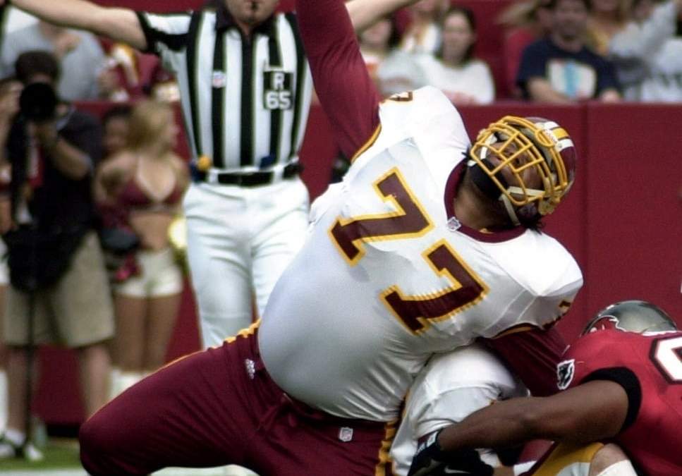 Tre Johnson (77), de los Redskins de Washington, se lesiona la pierna en el primer cuarto contra los Buccaneers de Tampa Bay en Landover, Maryland, el domingo 1 de octubre de 2000