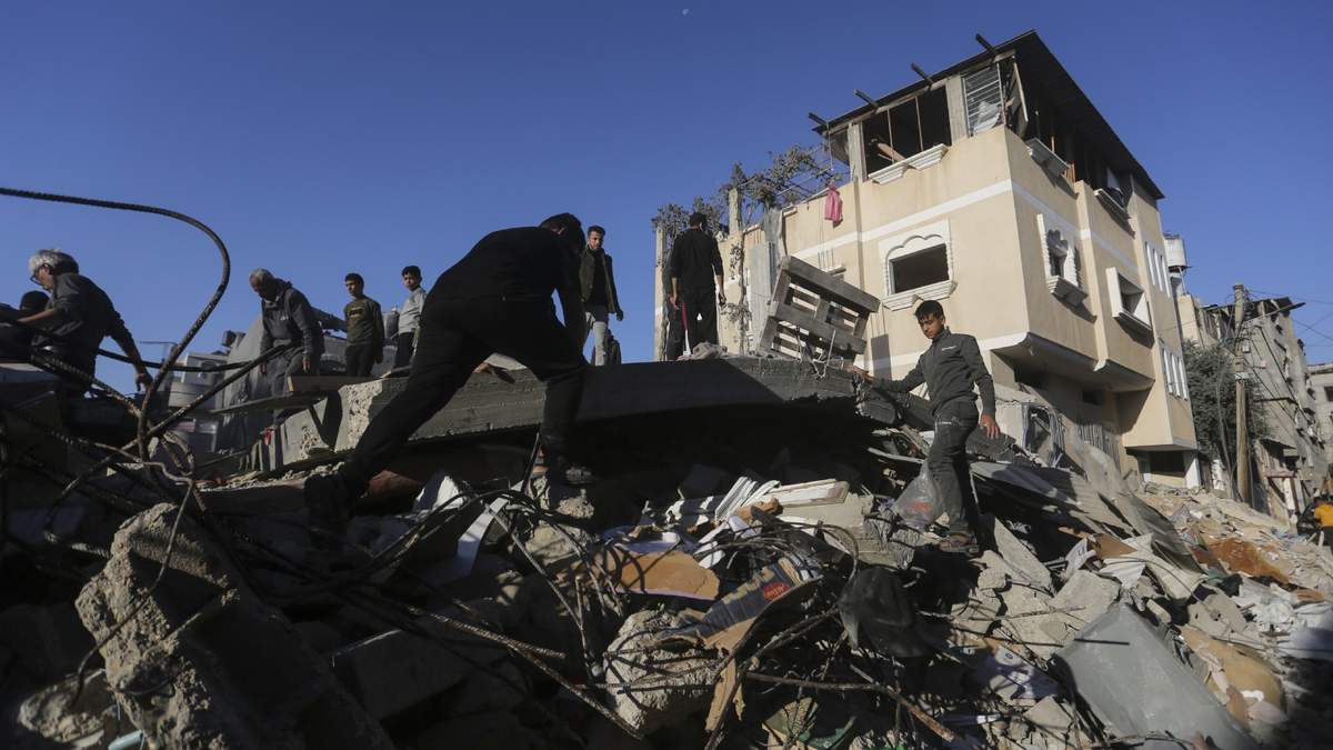 Los palestinos buscan sobrevivientes de un bombardeo israelí sobre la Franja de Gaza, en Rafah