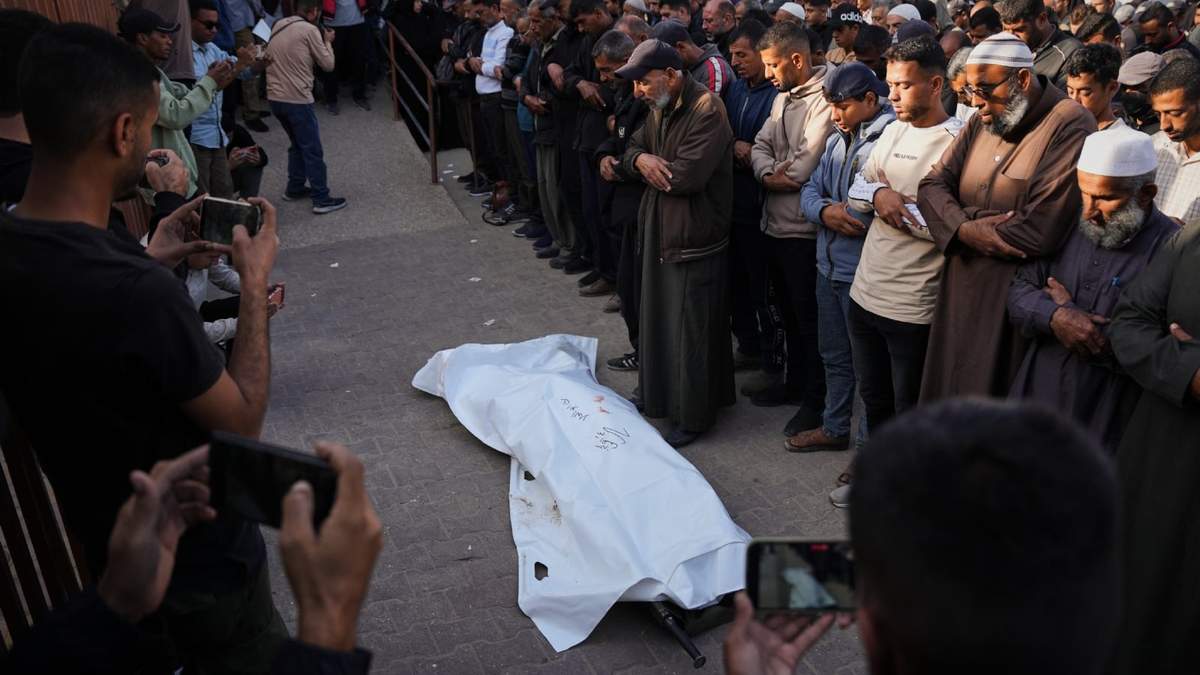 Dolientes rezan junto al cuerpo de Ruba Abu Al-Ola, de 22 años, que murió en un ataque del ejército israelí, durante su funeral en el hospital Nasser, en Jan Yunis, Gaza, el 20 de noviembre de 2025