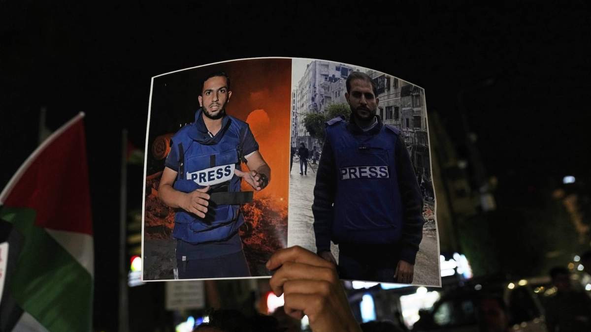 Una mujer lleva un cartel que muestra a los periodistas palestinos Anas al-Sharif y Mohamed Qreiqeh