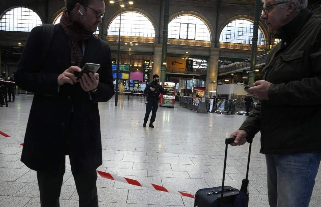 Viajeros esperan detrás de un cordón policial en la estación Gare du Nord, en París