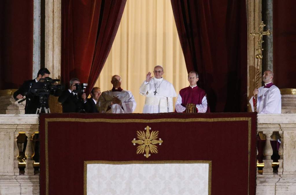 ARCHIVO - El papa Francisco, flanqueado por el monseñor Guido Marini, maestro de ceremonias litúrgicas, saluda a la multitud desde el balcón central de la basílica de San Pedro, en el Vaticano, tras ser elegido papa el miércoles 13 de marzo de 2013