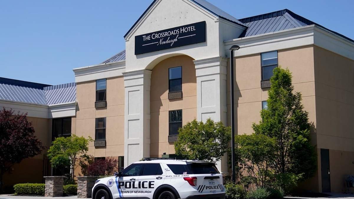 Un vehículo policial estacionado afuera del hotel The Crossroads, adonde llegaron dos autobuses con migrantes el 11 de mayo d 2023
