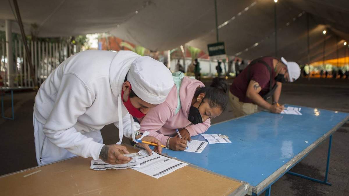 Jóvenes llenan su formulario para la vacunación contra covid-19 en Xochimilco.