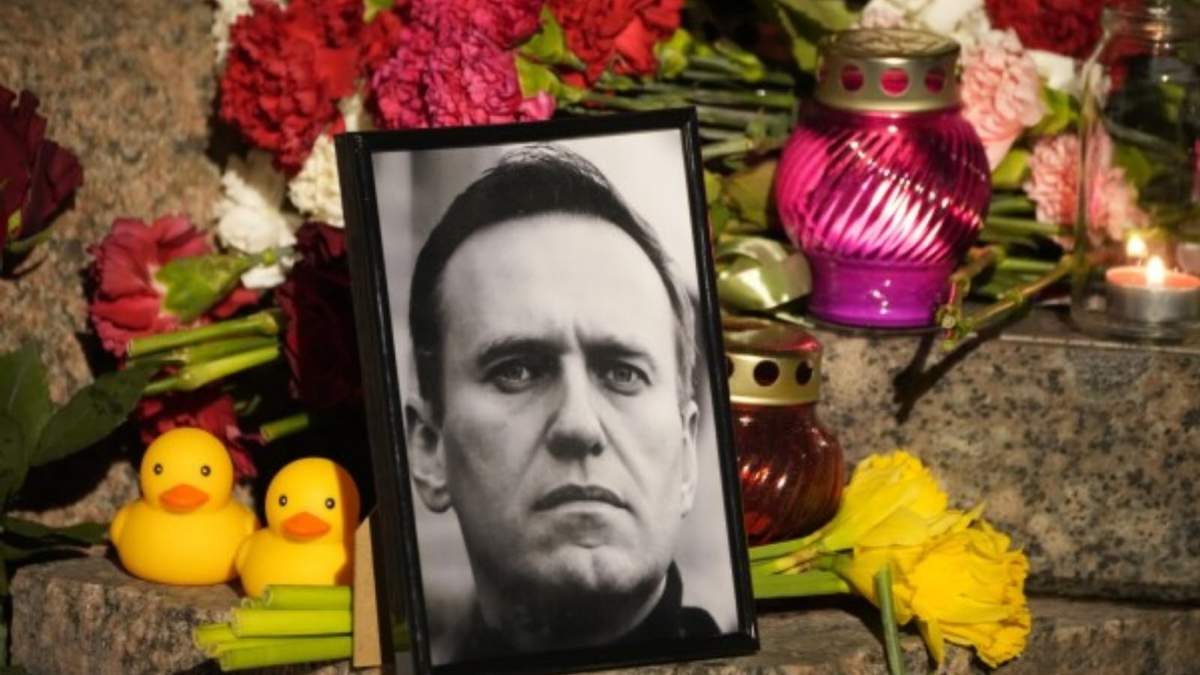 Un retrato del líder opositor ruso Alexei Navalny, flores y velas, durante un homenaje al activista en un monumento a las víctimas de la represión política, en San Petersburgo, Rusia