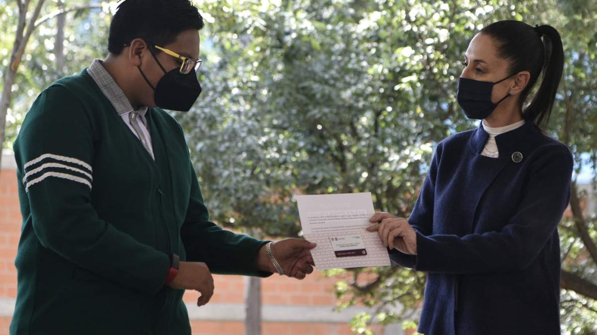 Sheinbaum entrega una tarjeta a un alumno de secundaria