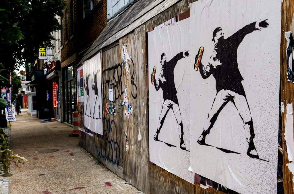 ARCHIVO – Carteles de una persona arrojando un sándwich a lo largo de H Street, el 17 de agosto de 2025, en Washington