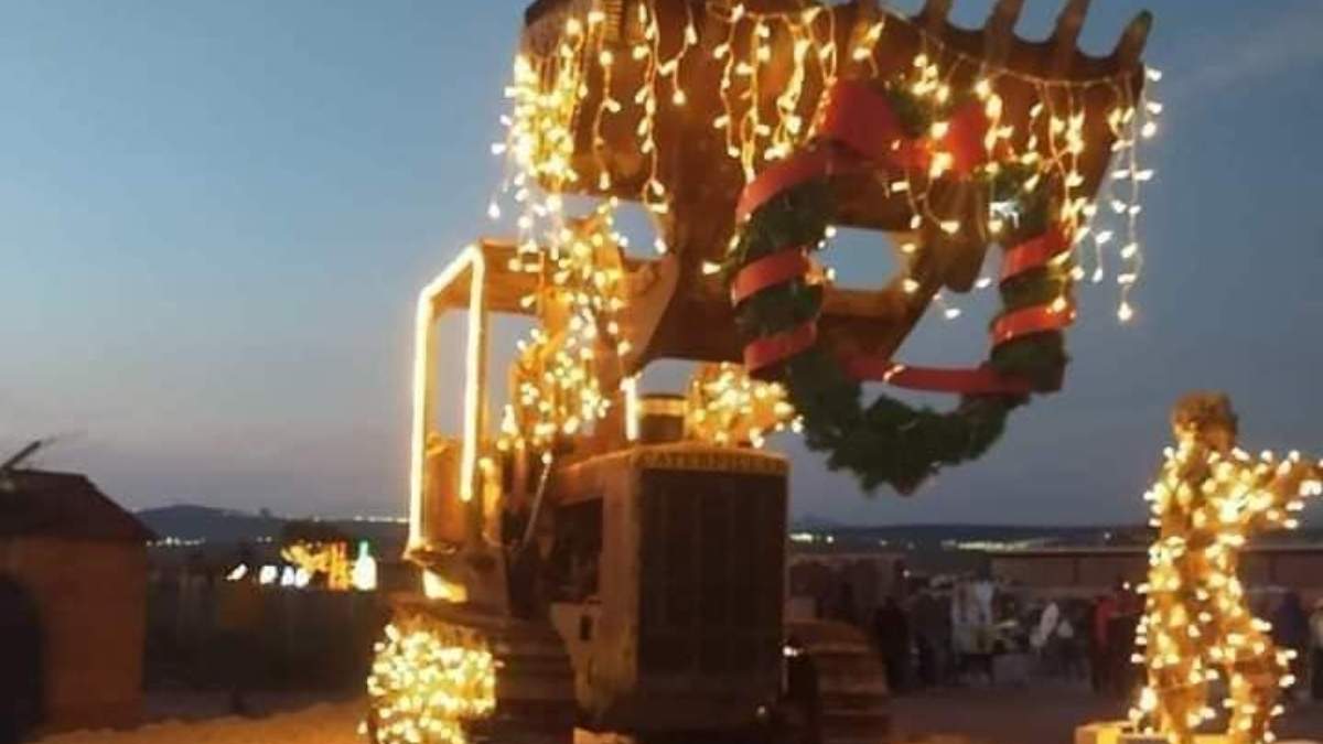 Una retroexcavadora adornada con luces navideñas