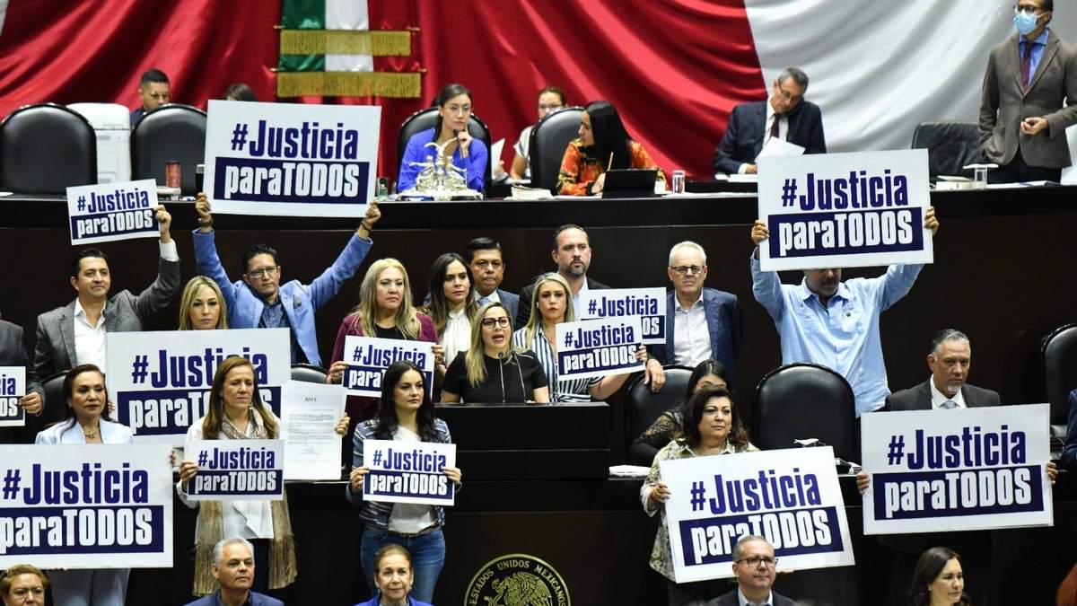 Opositores a la iniciativa muestran pancartas en tribuna