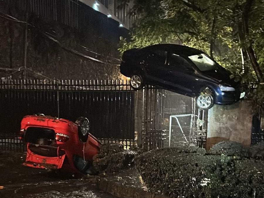 Automóvil queda suspendido sobre una reja a causa de las lluvias en la CDMX