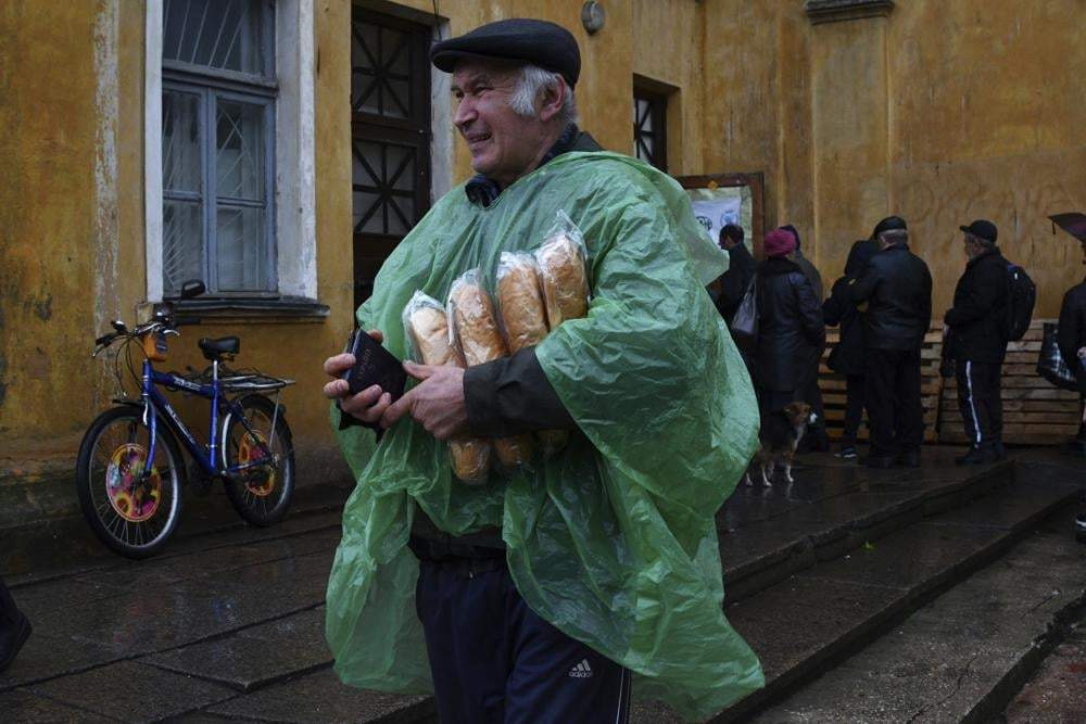Un hombre lleva un pasaporte ucraniano y pan después de recibirlo en un centro de ayuda humanitaria en Kramatorsk el 26 de octubre de 2022