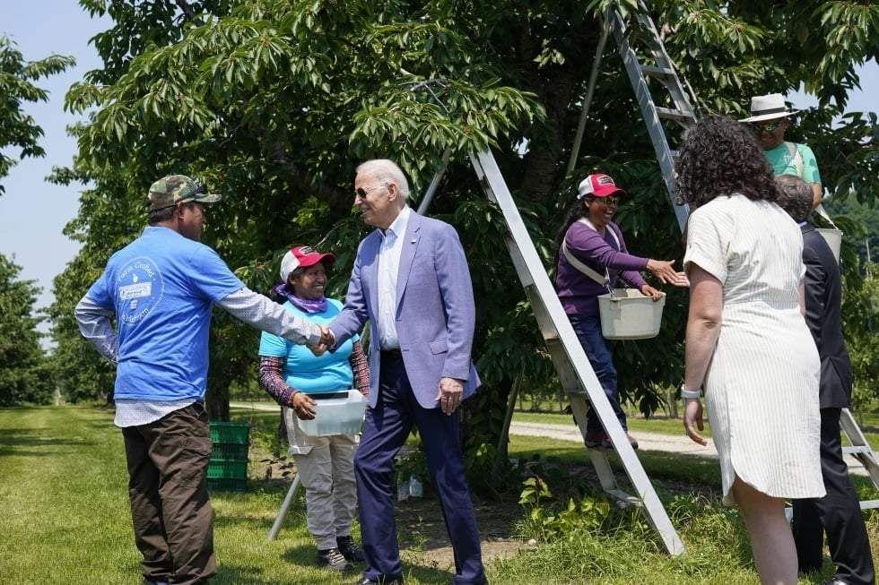 El presidente Joe Biden saluda a unos trabajadores agrícolas en Central Lake, Michigan