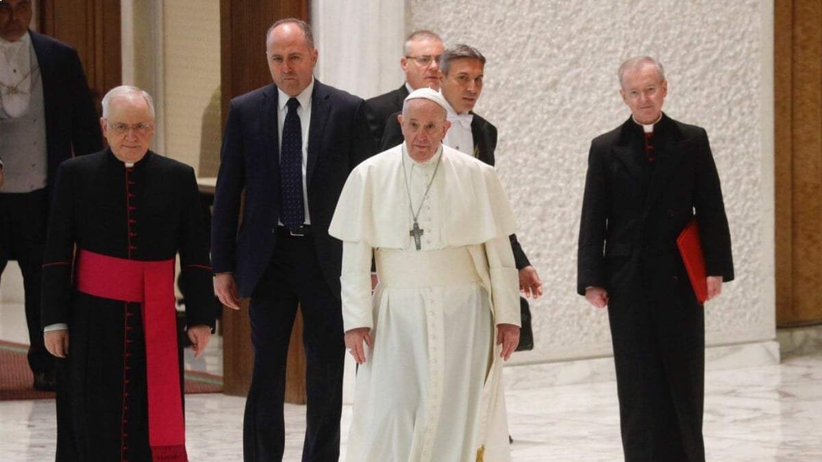 El Papa Francisco y varios empleados caminan en el Vaticano