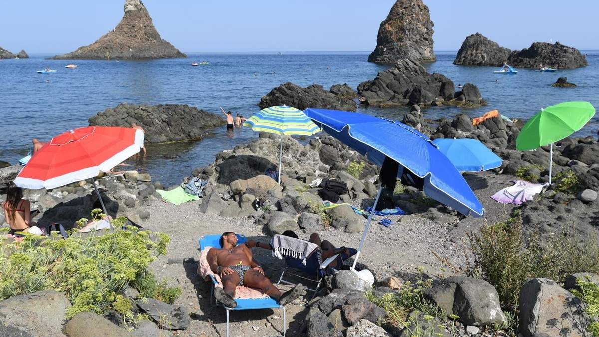 En esta imagen de archivo, bañistas disfrutan de un día de playa en Aci Trezza, cerca de Catania, Sicilia, Italia