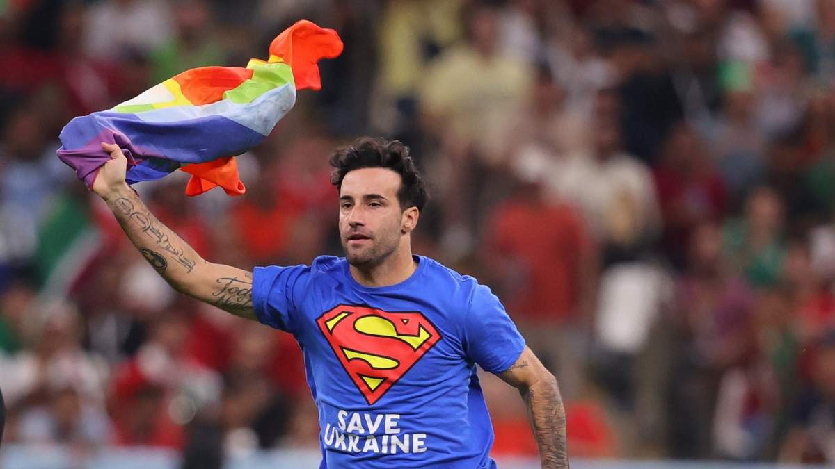 Aficionado que saltó a la cancha con bandera arcoíris y una camiseta azul de Superman