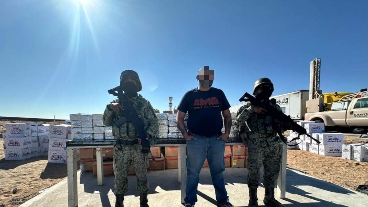 El detenido junto con los paquetes con droga