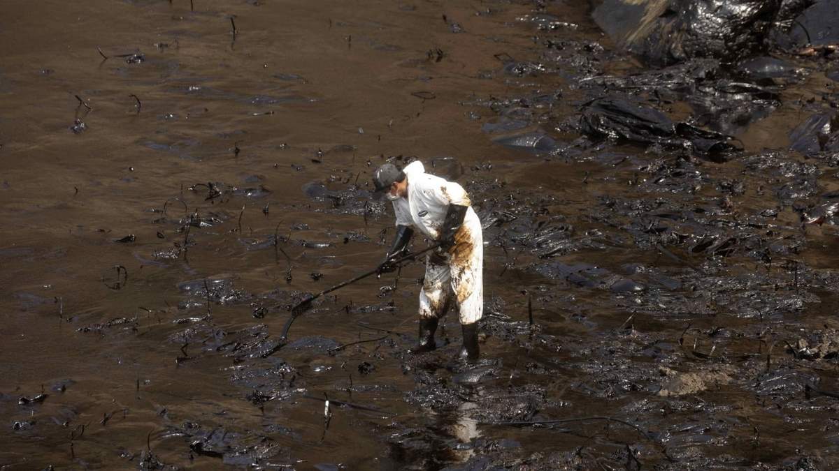 Un brigadista limpia las costas de Perú tras el derrame de petróleo. Fuente: (Twitter)