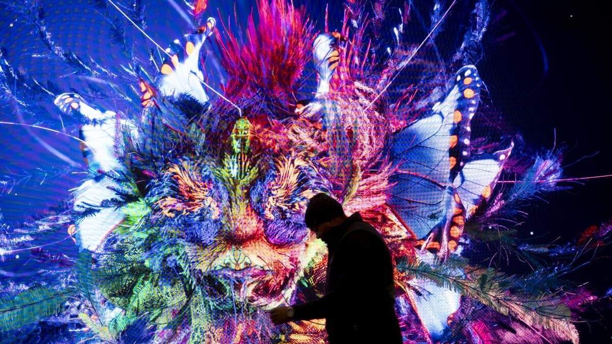 Un hombre pasa ante una pantalla con una imagen generada con inteligencia artificial por el artista Refik Anadol, en el Centro de Congresos donde se celebra la reunión del Foro Económico Mundial en Davos, Suiza