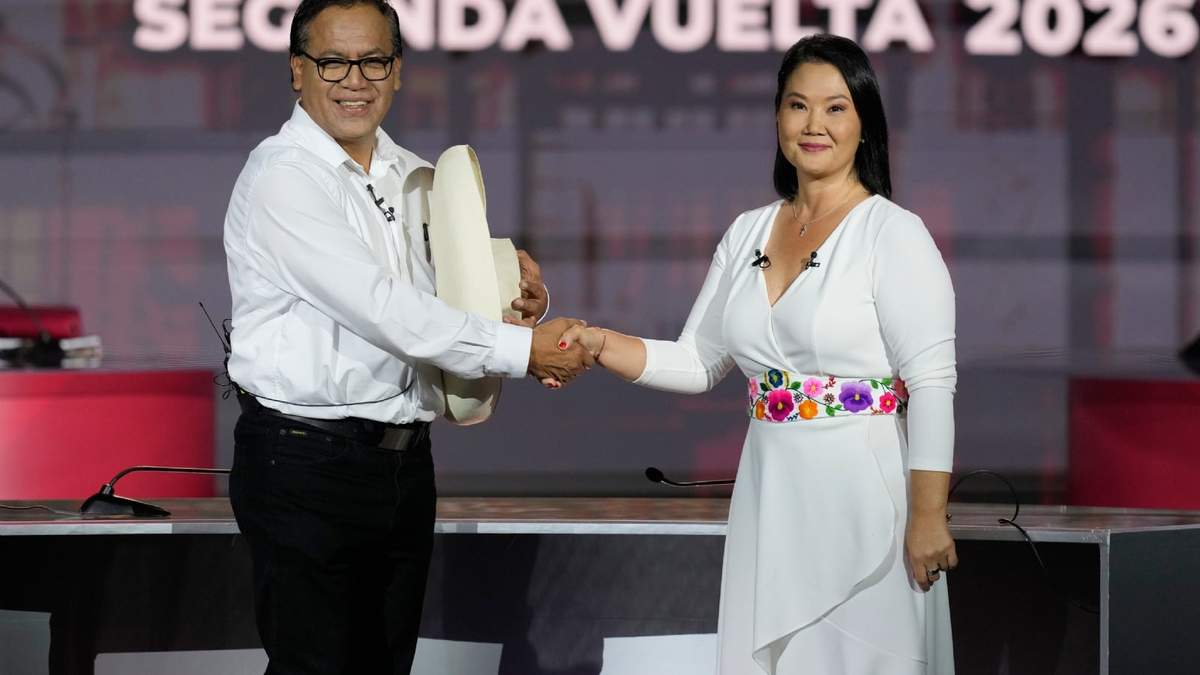 Los aspirantes a la presidencia de Perú Keiko Fujimori, de Fuerza Popular, y Roberto Sánchez, de Juntos por Perú, se dan la mano antes de un debate presidencial en Lima, Perú