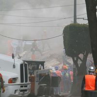 Incendio en edificio derrumbado complica labores de rescate