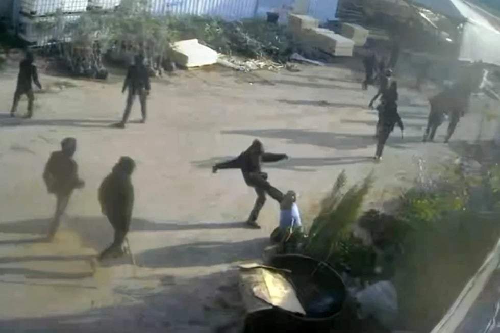 En esta imagen, tomada de una grabación de seguridad realizada el 8 de enero de 2026 y obtenida por The Associated Press, hombres vestidos de negro y con los rostros ocultos --uno de ellos pateando a un hombre en el piso-- atacan un vivero de plantas en Deir Sharaf, en la Cisjordania ocupada.