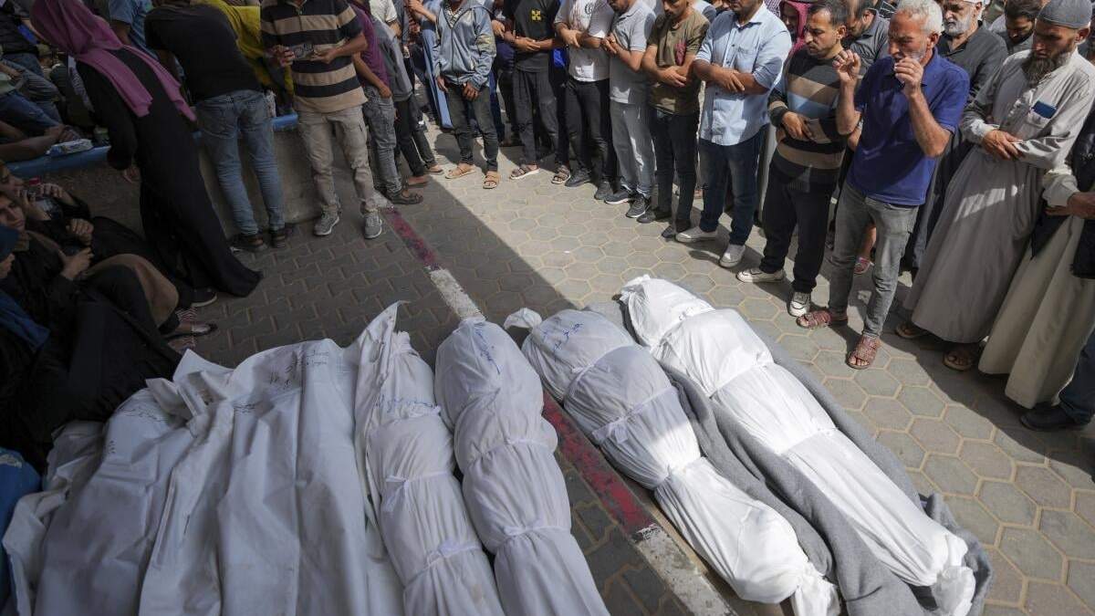 Dolientes rezan junto a los cuerpos de palestinos muertos por un ataque aéreo israelí en el hospital Al Aqsa