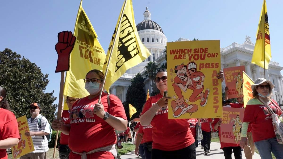 Trabajadores de comida rápida y sus partidarios marchan frente al Capitolio del estado de California en Sacramento, el 16 de agosto de 2022