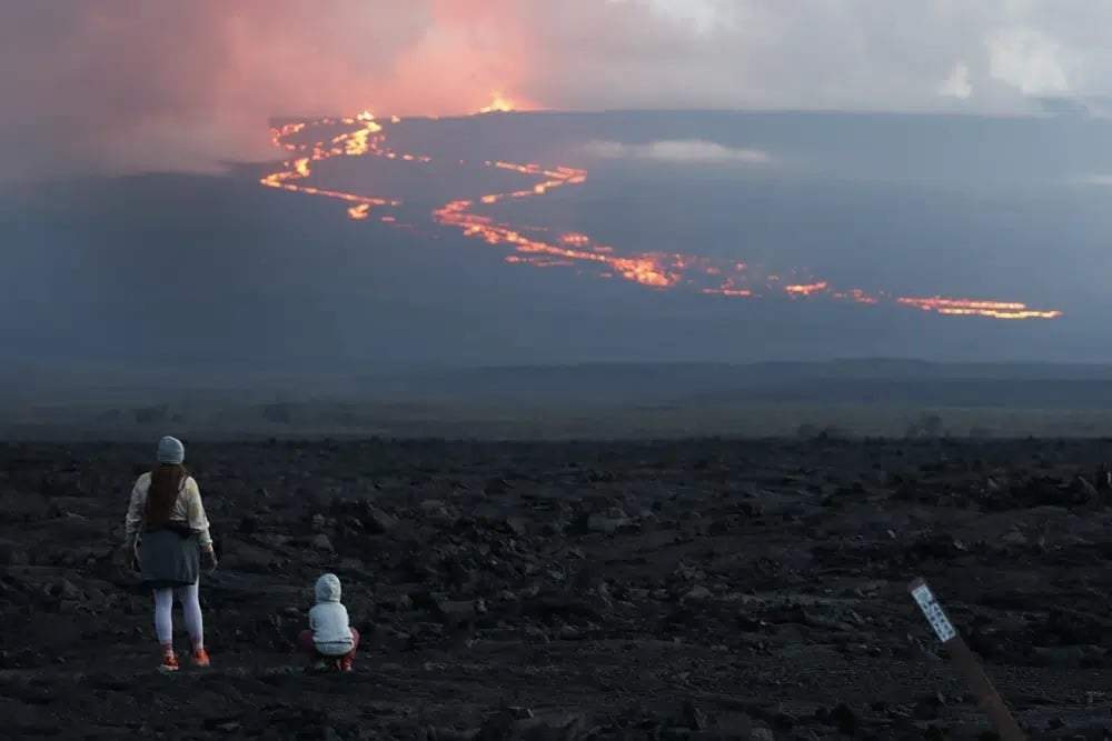 Espectadores contemplan el flujo de lava en la erupción del volcán Mauna Loa, cerca de Hilo, Hawái, 29 de noviembre de 2022