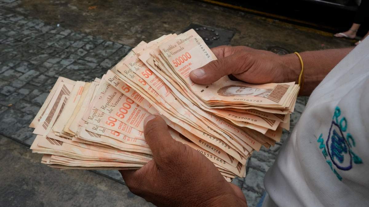 Un hombre sostiene 4 millones 31 mil bolívares, que equivalen a un dólar en Caracas, Venezuela