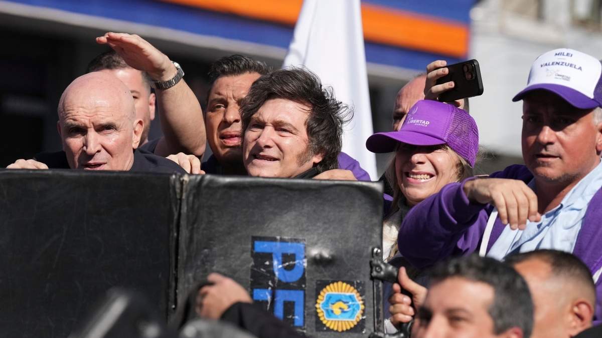 La policía protege a Javier Milei y a su hermana Karina Milei de los objetos que les arrojaron los manifestantes durante un mitin previo a las elecciones legislativas provinciales en Lomas de Zamora