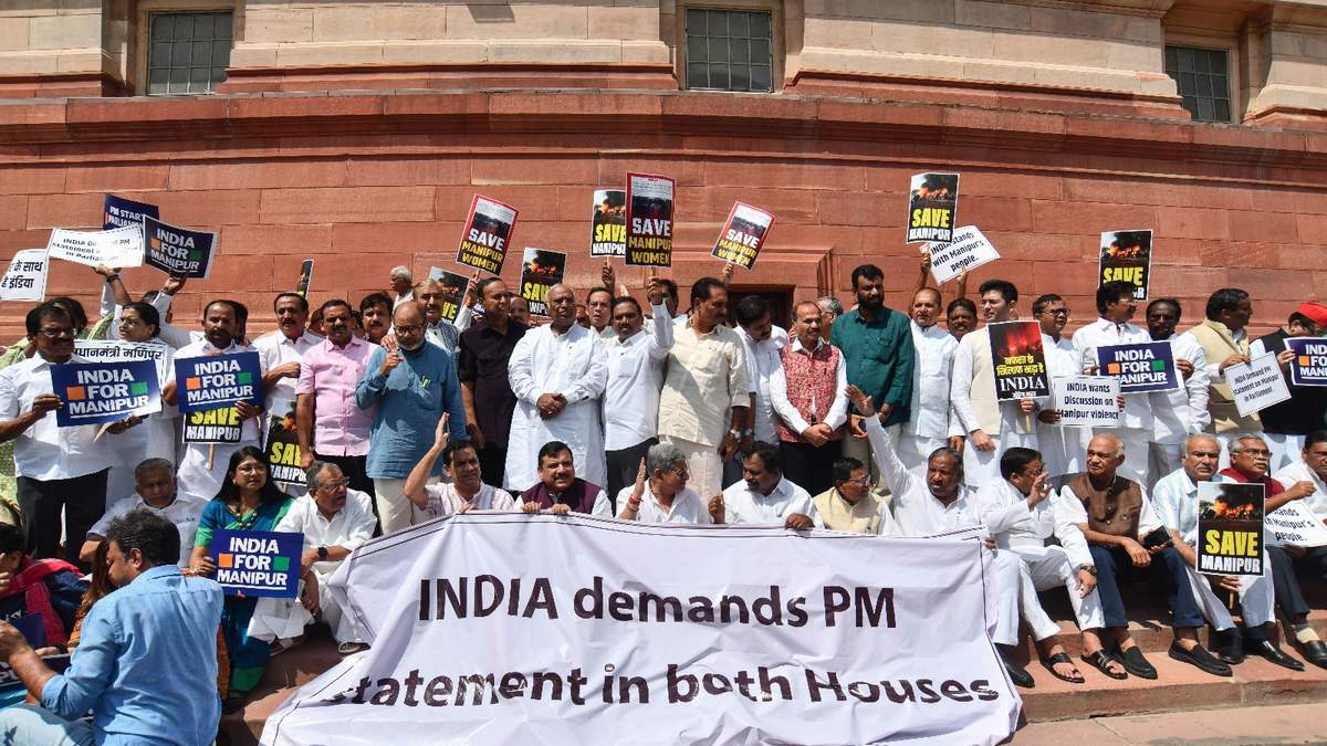 Legisladores de oposición sostienen carteles y una manta con el acrónimo "INDIA"