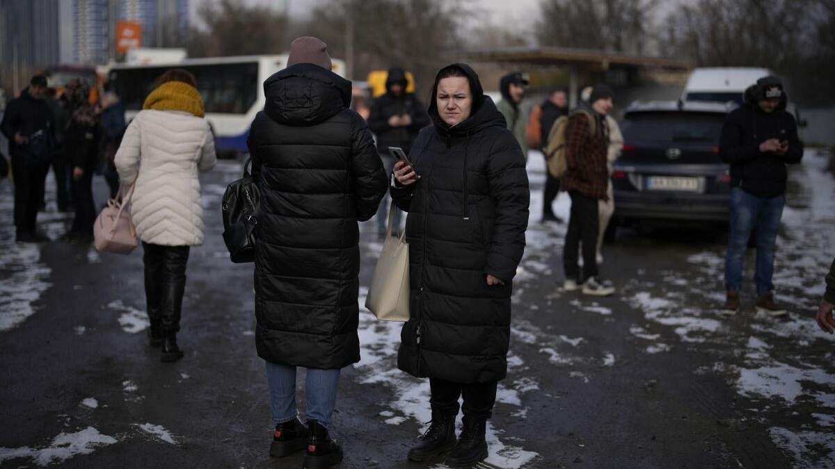 Gente esperando en una calle cortada por la policía tras un ataque de cohete en Kiev, Ucrania, el jueves 26 de enero de 2023. (AP Foto/Daniel Cole)