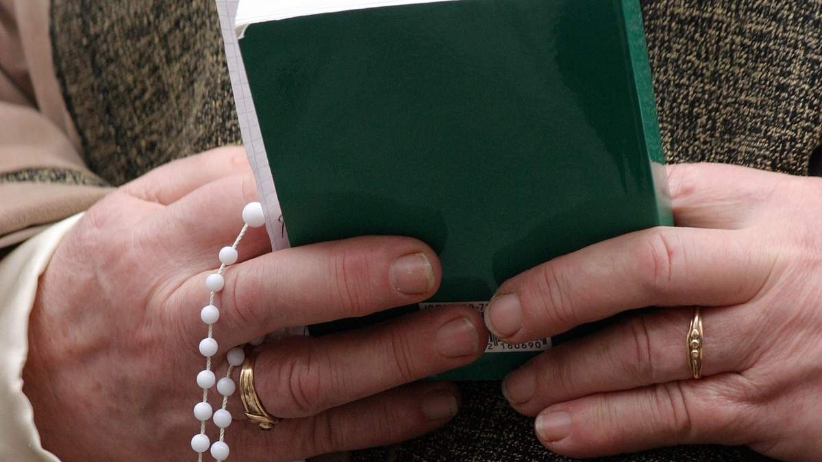 Una mujer sostiene una Biblia y un rosario