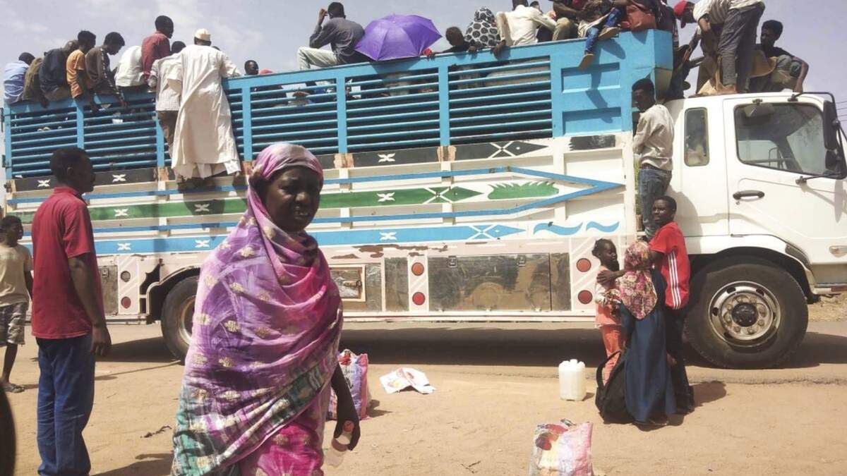 Varias personas abandonan la capital de Sudán, Jartum, a bordo de un camión, en Sudán