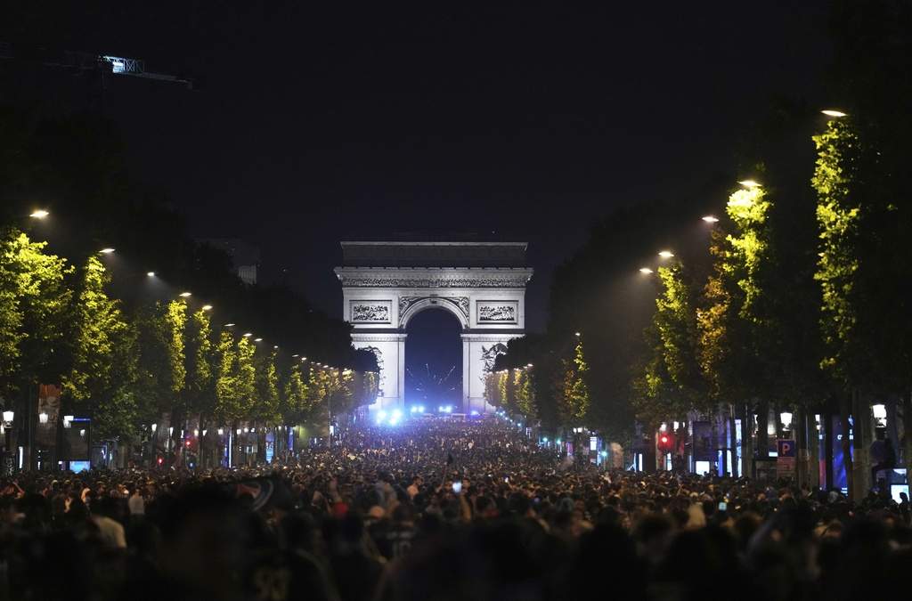Aficionados al fútbol celebran la victoria del PSG en la avenida de los Campos Elíseos, con el Arco de Triunfo al fondo, tras la final de la Champions League entre el Paris Saint-Germain y el Inter de Milán, el domingo 1 de junio de 2025 en París