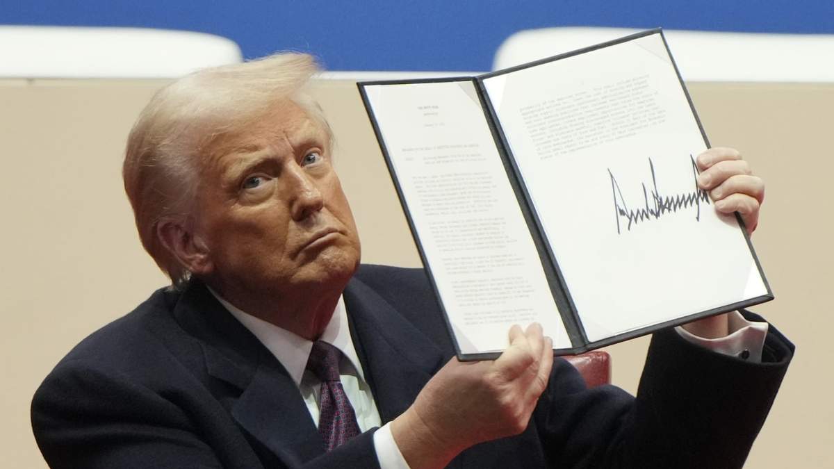 El presidente Donald Trump sostiene una orden ejecutiva después de firmarla en un desfile inaugural presidencial en Washington