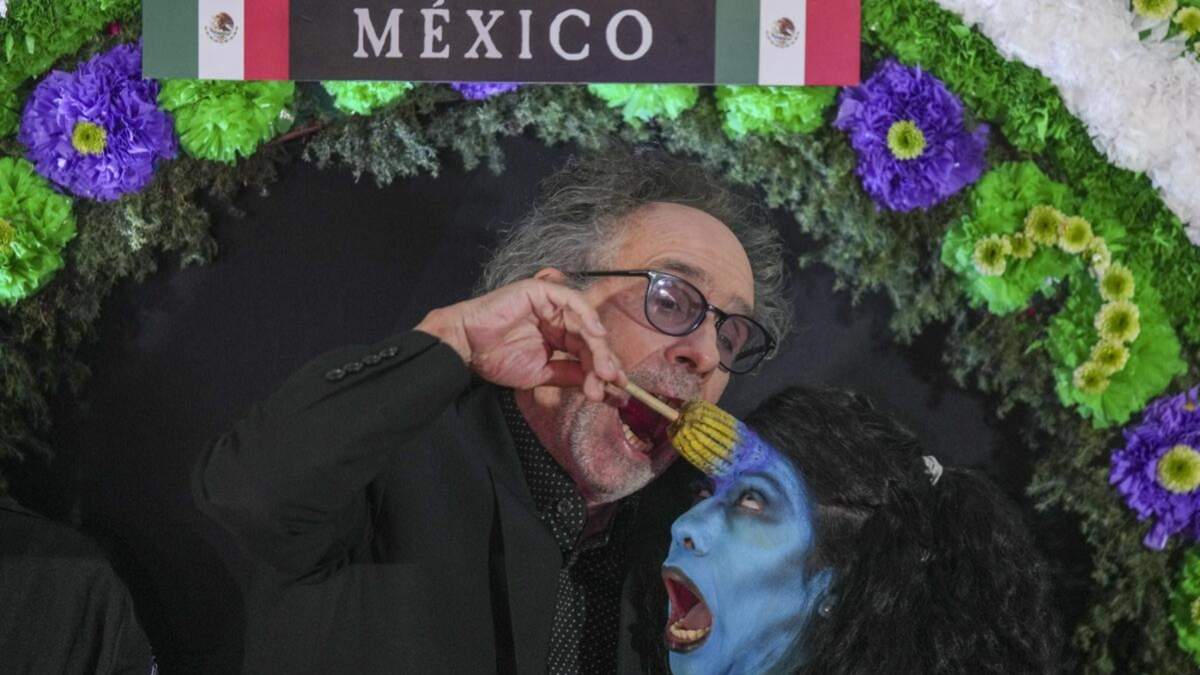El director Tim Burton bromea con una actriz disfrazada durante un evento promocional de su película Beetlejuice Beetlejuice en la Ciudad de México, el martes 13 de agosto de 2024