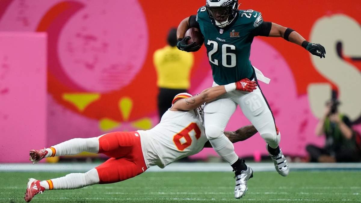Saquon Barkley (26), corredor de los Eagles de Filadelfia, intenta eludir la tacleadade Bryan Cook (6), safety de los Chiefs de Kansas City, durante la primera mitad del Super Bowl 59 de la NFL, el domingo 9 de febrero de 2025, en Nueva Orleans