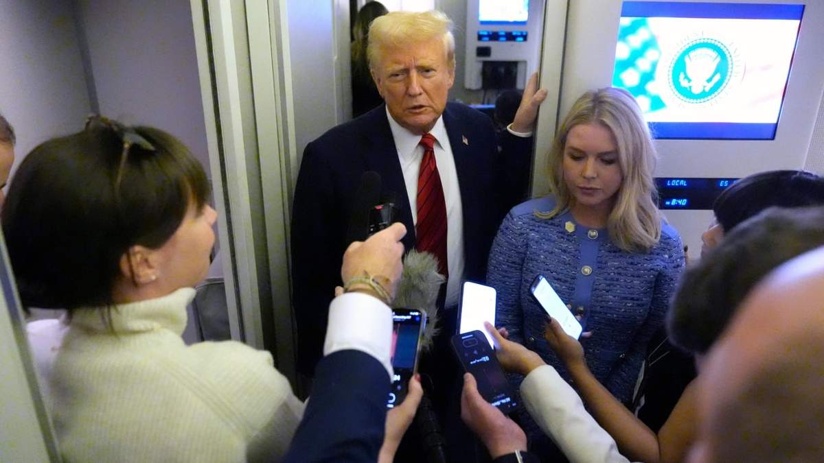 El presidente Donald Trump habla con periodistas a bordo del Air Force One mientras la secretaria de prensa de la Casa Blanca, Karoline Leavitt, escucha