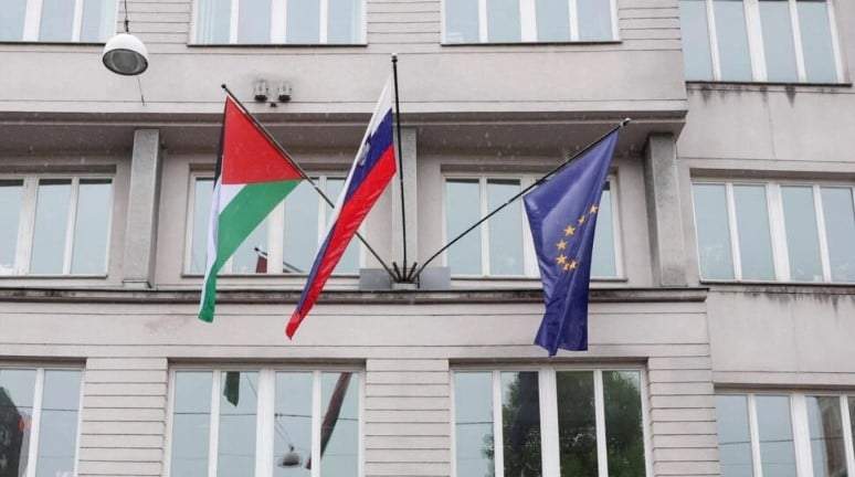 Una bandera palestina ondea junto a una bandera eslovena y una bandera de la Unión Europea en el edificio del gobierno en Liubliana, Eslovenia