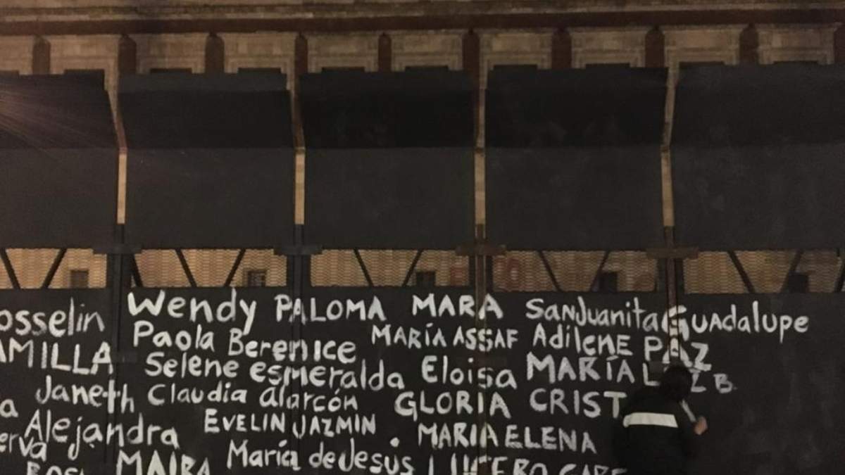 Activistas pintan los nombres de mujeres asesinadas en las vallas colocadas en Palacio Nacional