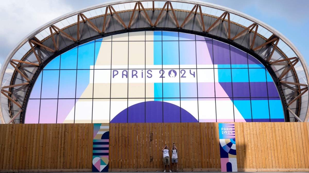 Turistas toman fotos en la Arena del Campo de Marte, previo a los Juegos Olímpicos de París