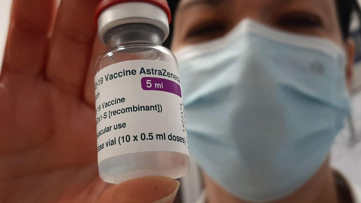 Una sanitaria sostiene un frasco con el fármaco de AstraZeneca. Fuente: (Twitter)